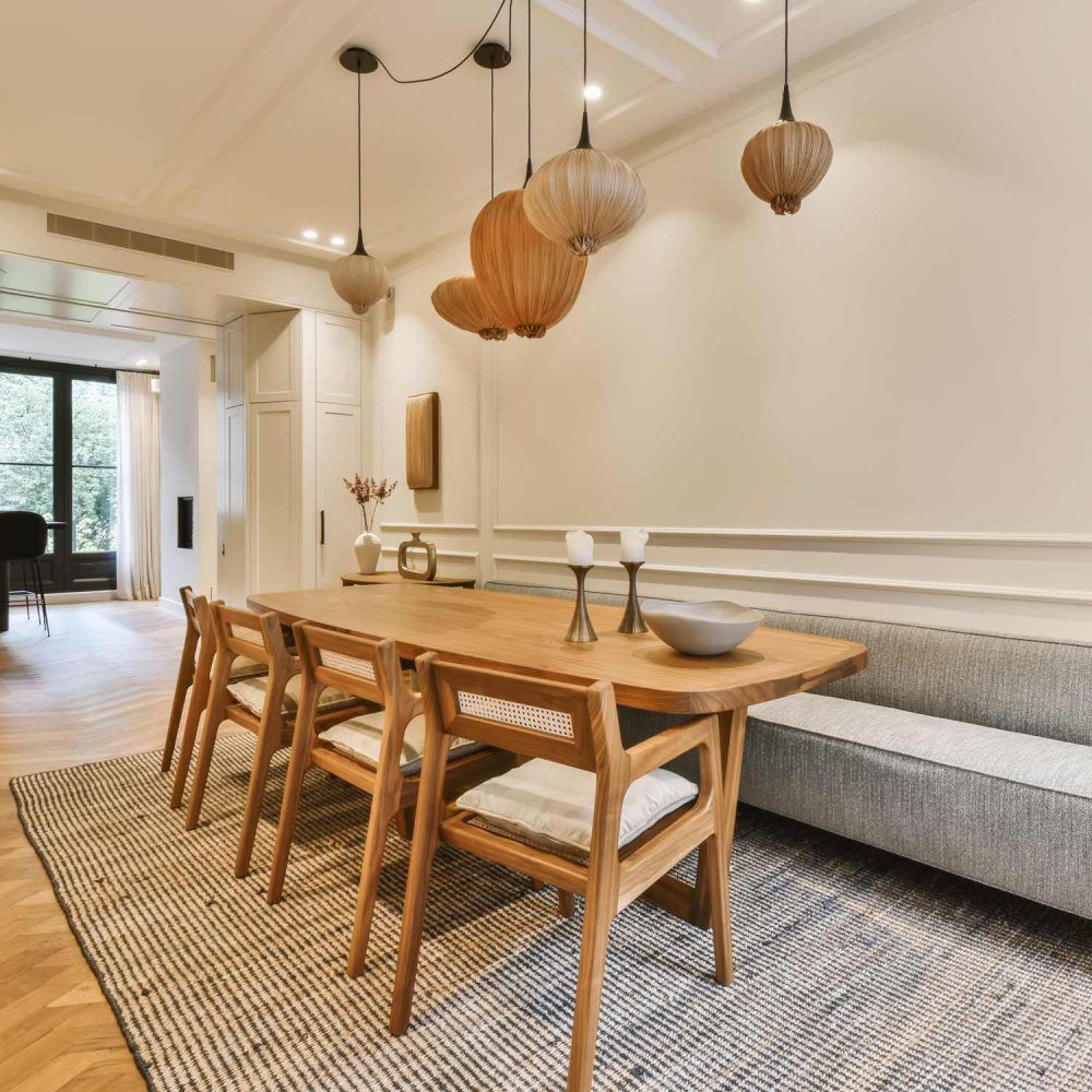 a dining room with wood flooring and white trim on the walls there is a wooden table that has two chairs in it